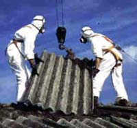 Homens manuseando telhas de amianto